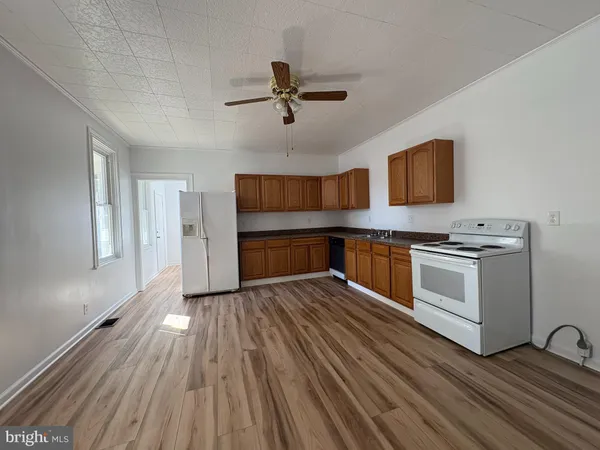 a kitchen with wooden floors and appliances