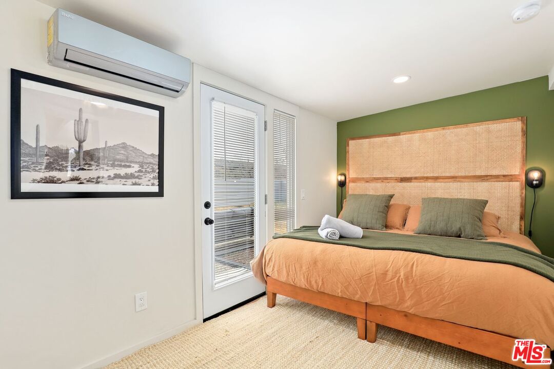 6763 Sunset Road Joshua Tree, CA 92252 - Photo 13 of 31 a bedroom with a large bed and a large window