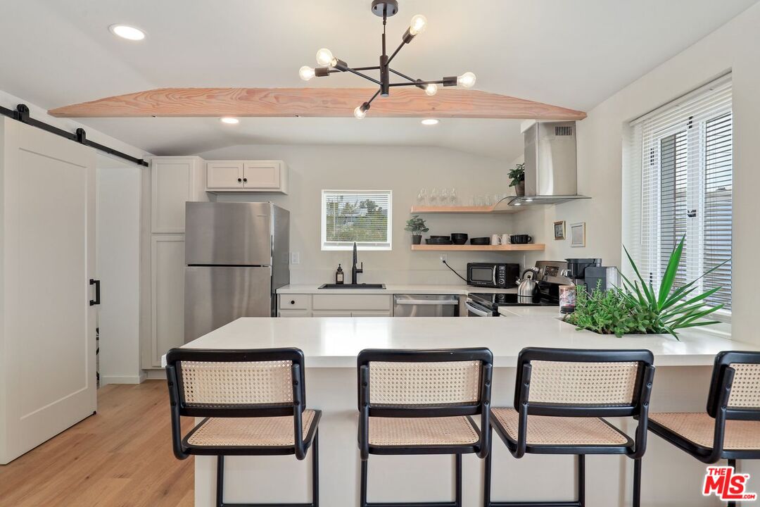 6763 Sunset Road Joshua Tree, CA 92252 - Photo 7 of 31 a kitchen with stainless steel appliances kitchen island a refrigerator and a table