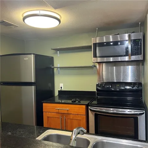 a kitchen with stainless steel appliances granite countertop a stove and a refrigerator