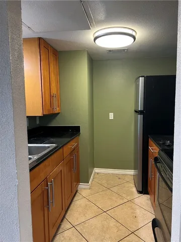a kitchen with stainless steel appliances granite countertop a refrigerator and a sink