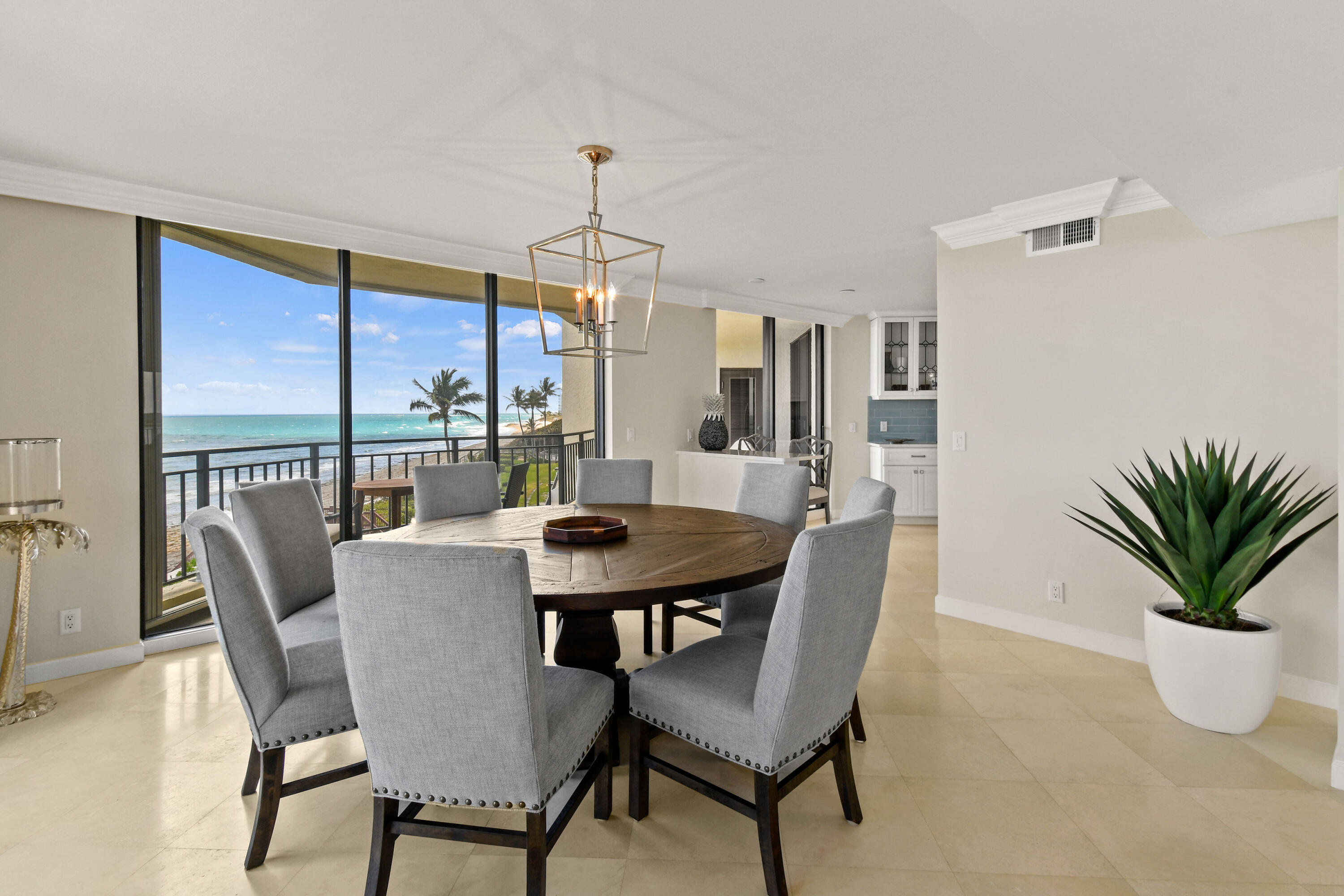 19850 South Beach Road, Unit 5A Jupiter, FL 33469 - Photo 22 of 78 a dining room with furniture potted plants and wooden floor