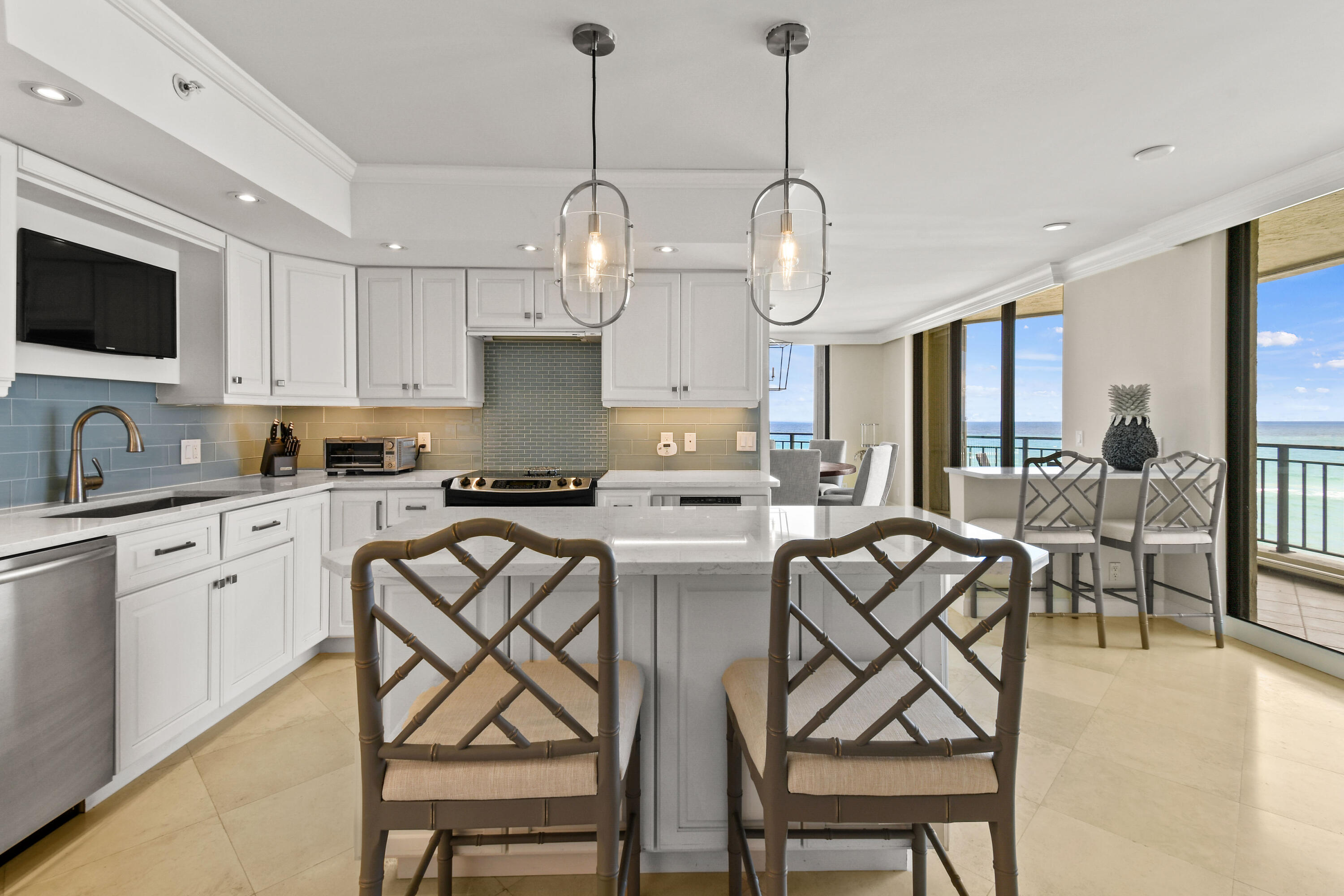 19850 South Beach Road, Unit 5A Jupiter, FL 33469 - Photo 32 of 78 a kitchen with stainless steel appliances granite countertop a stove a sink dishwasher a dining table and chairs with wooden floor