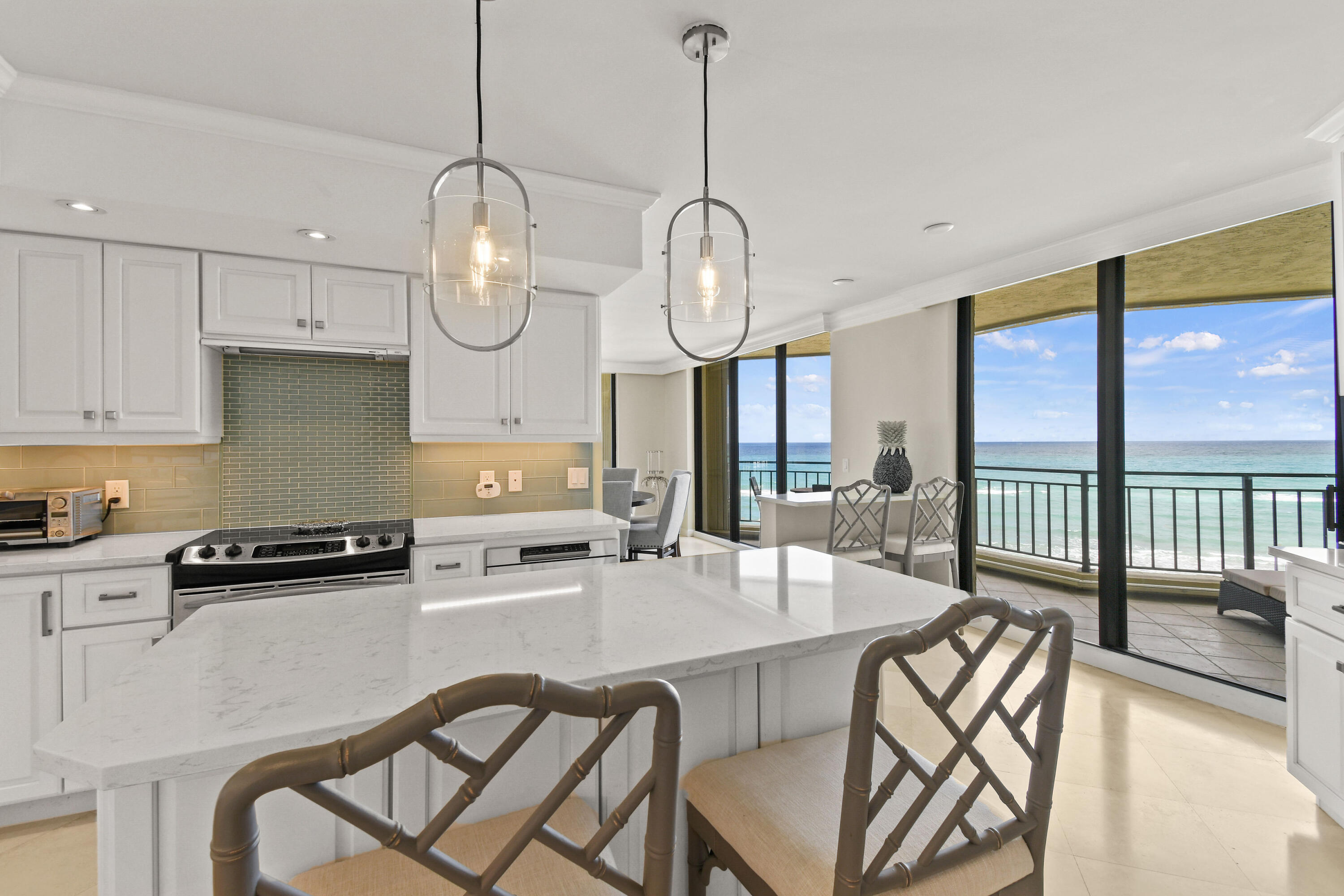 19850 South Beach Road, Unit 5A Jupiter, FL 33469 - Photo 33 of 78 a kitchen with stainless steel appliances granite countertop a dining table chairs stove and white cabinets