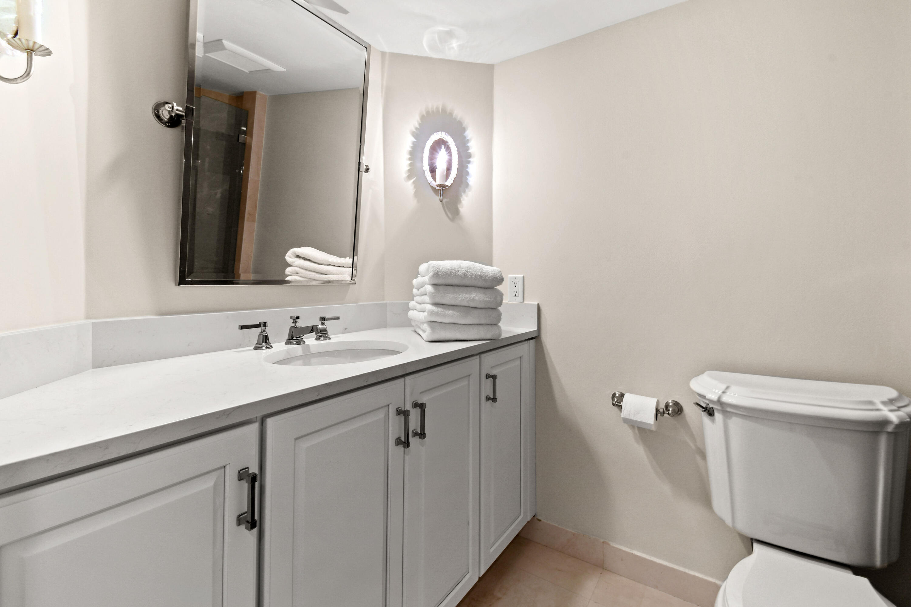 19850 South Beach Road, Unit 5A Jupiter, FL 33469 - Photo 52 of 78 a bathroom with a sink a toilet a mirror and vanity