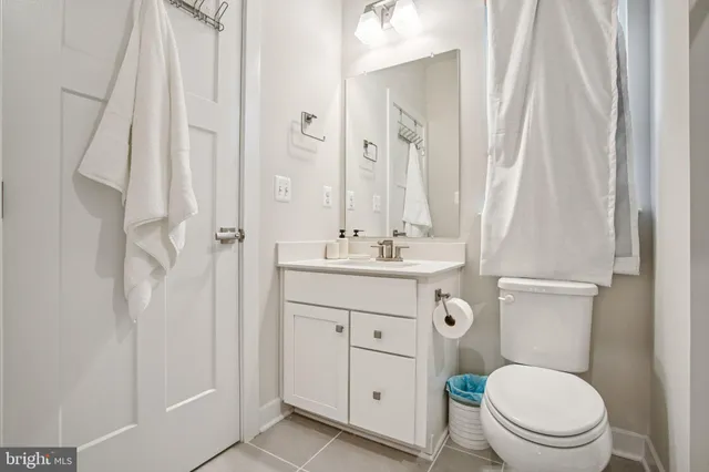 a kitchen with kitchen island a stove a sink a refrigerator and white cabinets with wooden floor