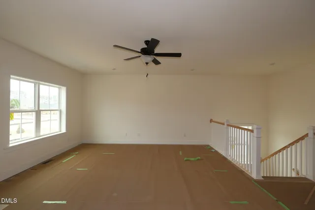 an empty room with a window and a ceiling fan