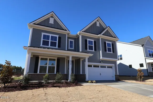 a front view of a house with yard and parking space