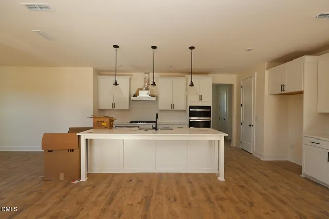 a kitchen that has a sink a stove and a wooden floor