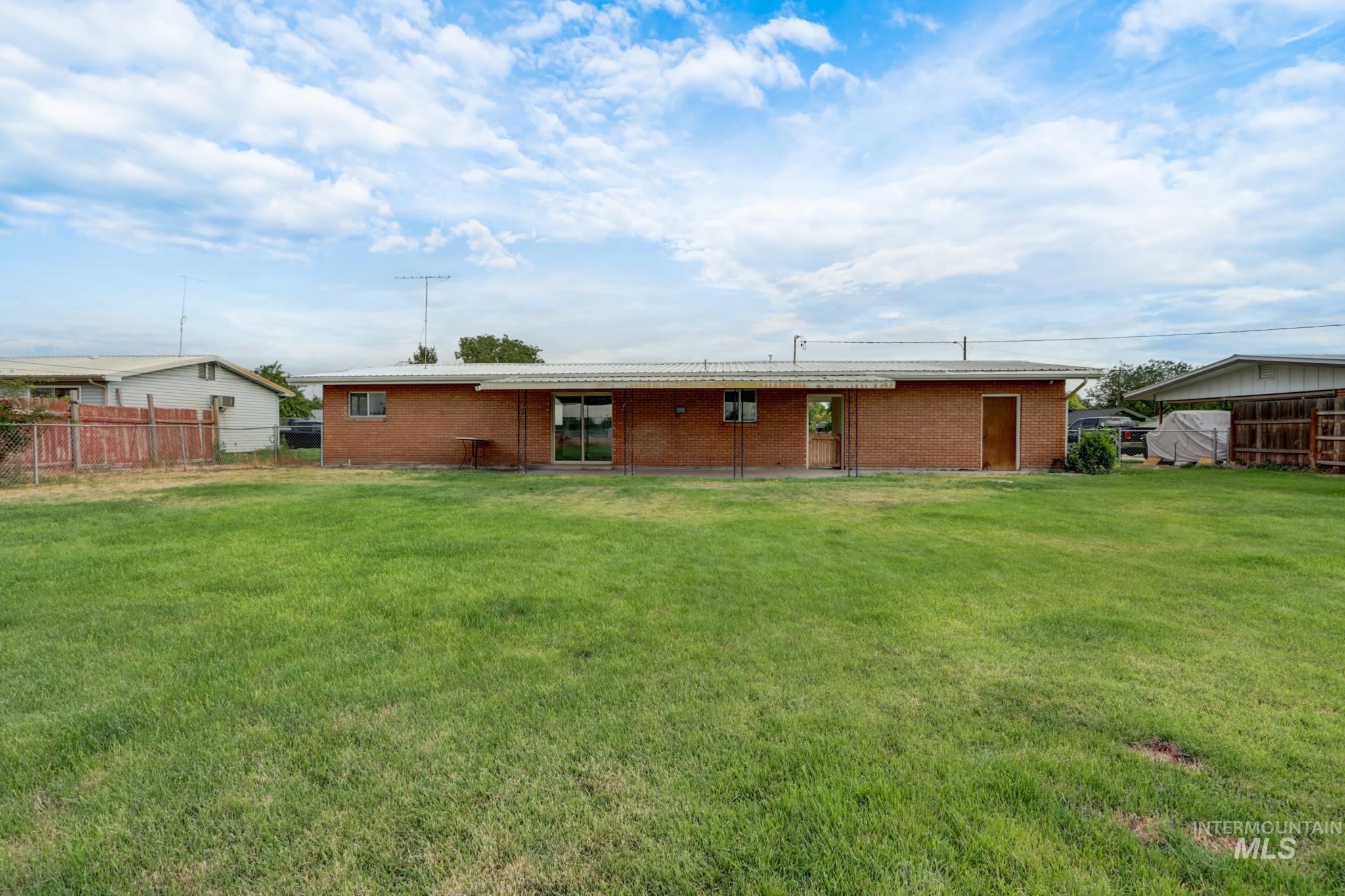 801 Thompson Avenue Nyssa, OR 97913 - Photo 41 of 46 Expansive green lawn with a brick exterior and covered patio