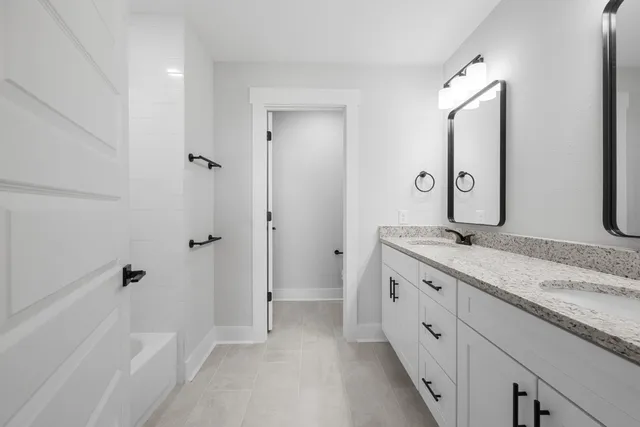 a bathroom with double sink and a mirror