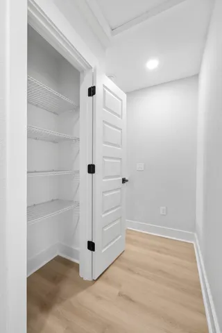 a view of a hallway with wooden floor and staircase