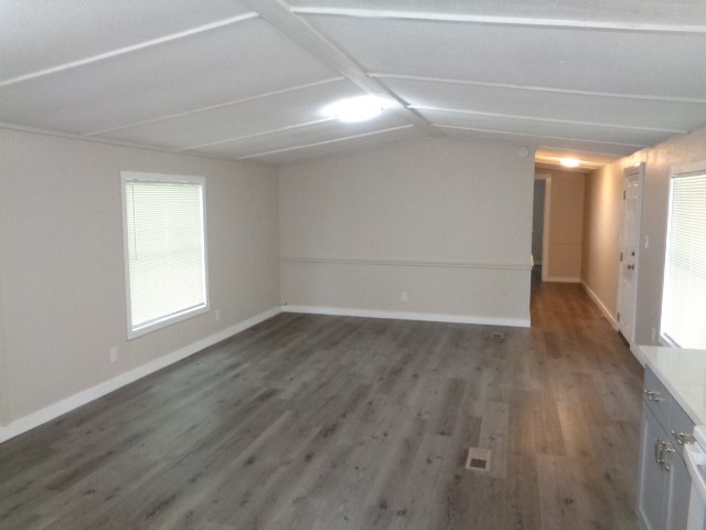 15120 Capitol Hill Road Montgomery, TX 77316 - Photo 9 of 17 an empty room with wooden floor and windows with curtains