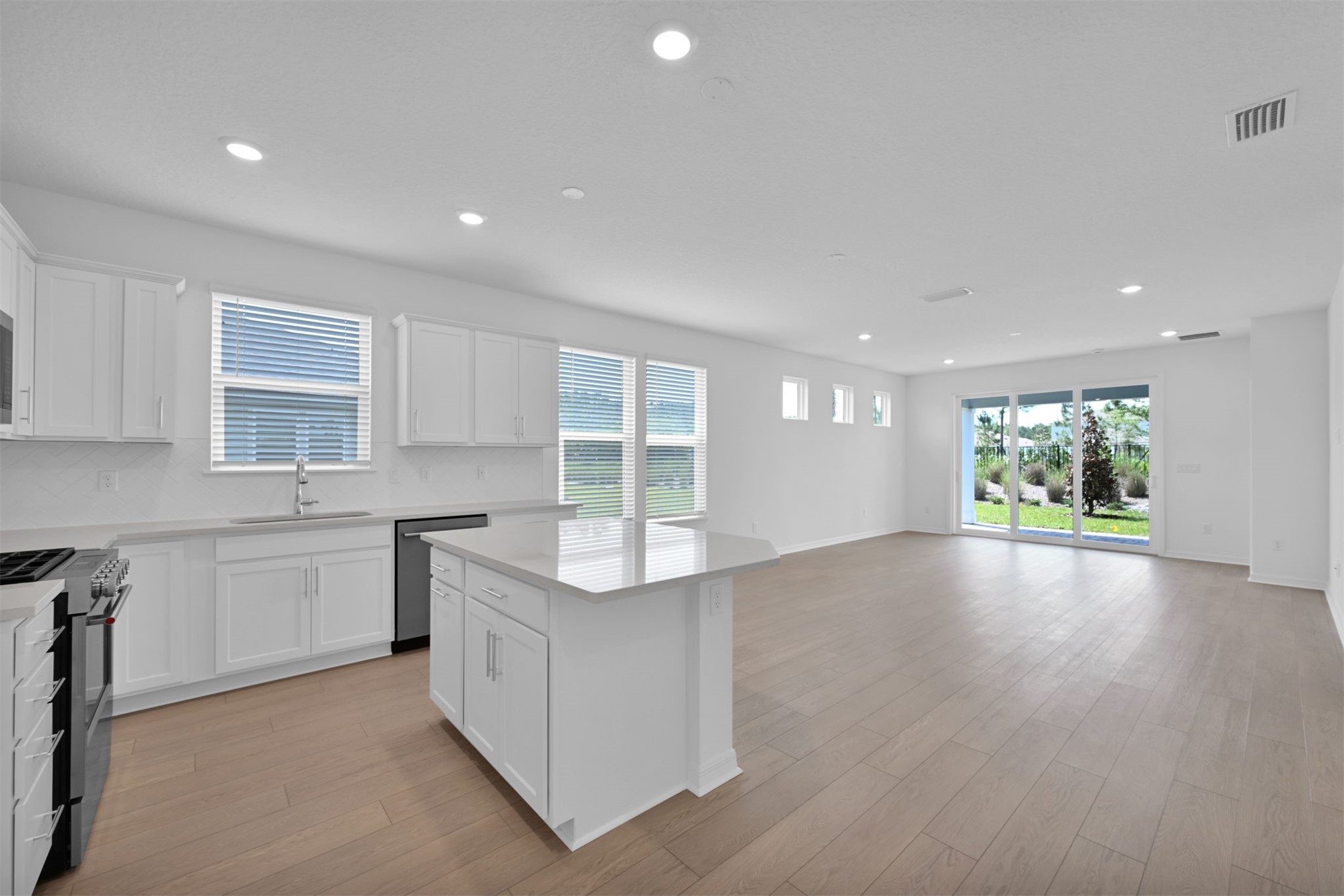 328 Ecliptic Loop Yulee, FL 32097 - Photo 6 of 41 a kitchen with stainless steel appliances granite countertop a stove top oven a sink dishwasher and a refrigerator with wooden floor