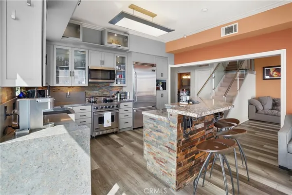 a kitchen with furniture a counter top space stainless steel appliances and a window