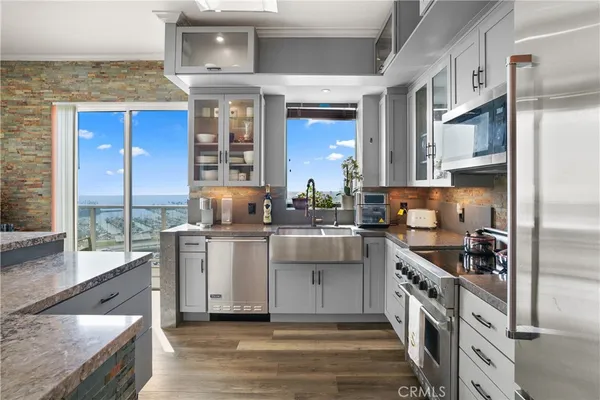 a kitchen with stainless steel appliances granite countertop a stove a sink and a refrigerator