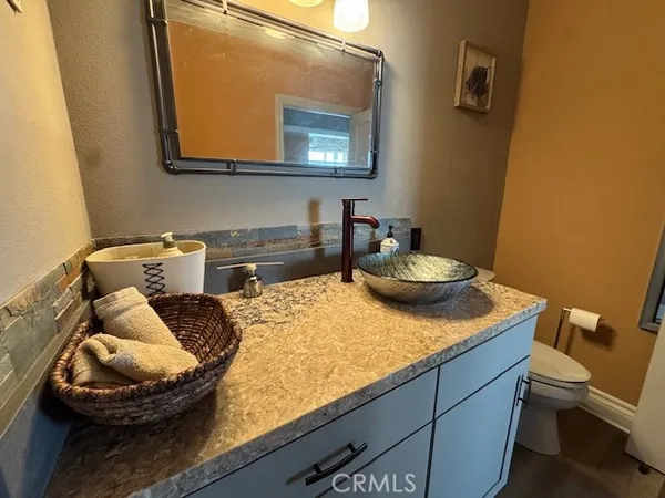 a kitchen with a sink and a stove with wooden floor