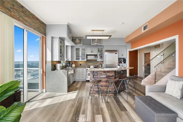 a dining room with stainless steel appliances granite countertop a couch and a view of kitchen