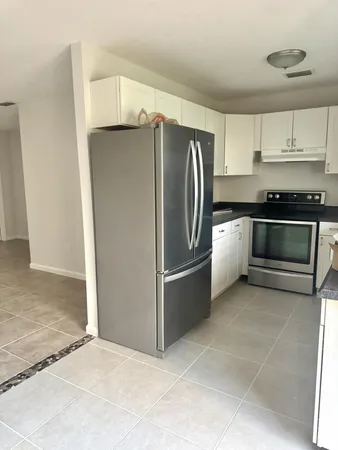 a kitchen with stainless steel appliances granite countertop a refrigerator and a stove