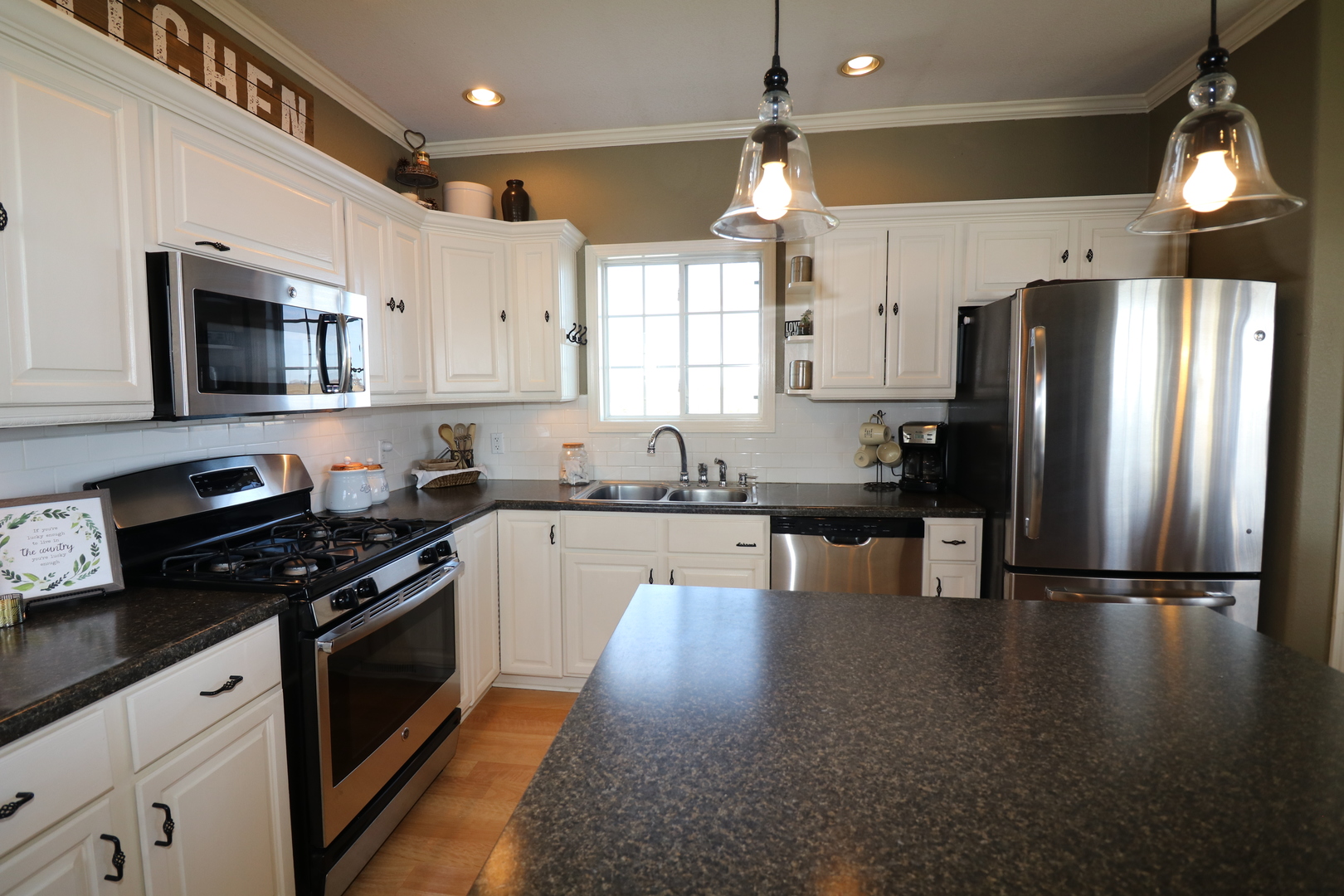 10942 Meridian Road Beason, IL 62512 - Photo 12 of 21 a kitchen with granite countertop a refrigerator a sink dishwasher a stove and white cabinets with wooden floor