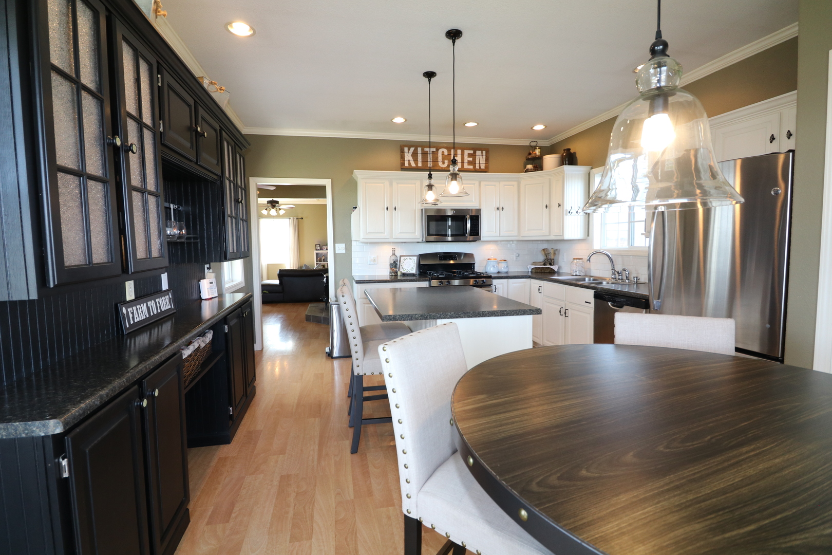 10942 Meridian Road Beason, IL 62512 - Photo 9 of 21 a large kitchen with stainless steel appliances kitchen island granite countertop a refrigerator a stove top oven a sink dishwasher and wooden cabinets with wooden floor