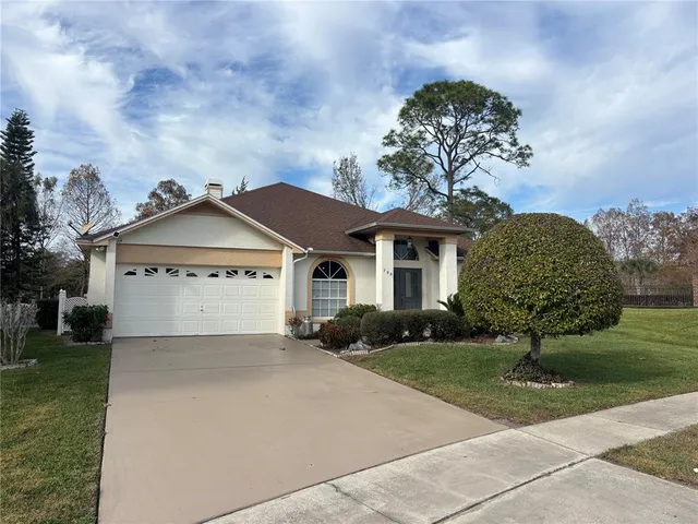 a front view of a house with a garden and trees
