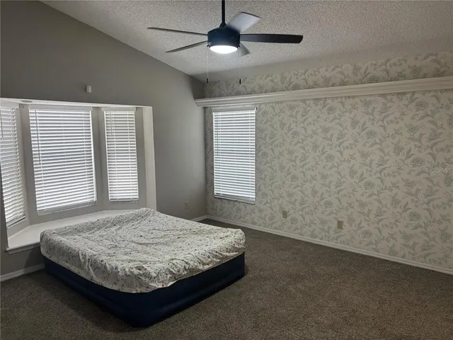 a bedroom with a bed and a ceiling fan