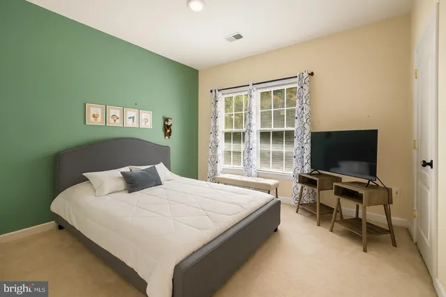 a bedroom with a bed and a flat screen tv on dresser