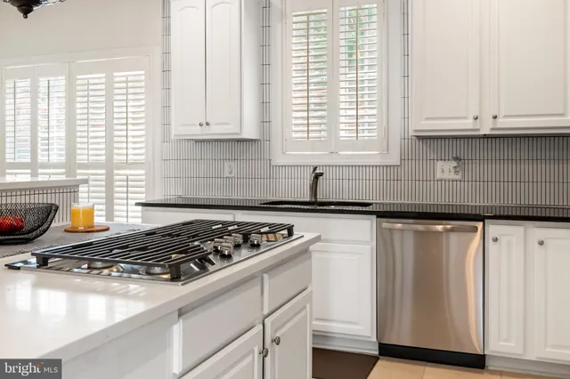 a kitchen with granite countertop cabinets stainless steel appliances and a sink