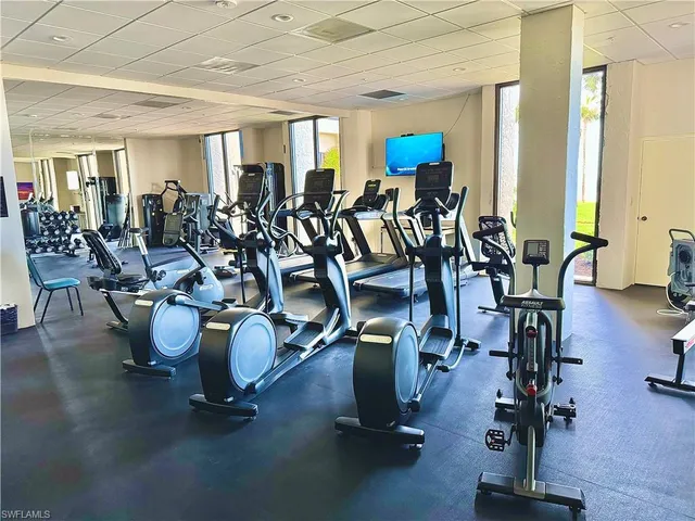 a dining room with wooden floor a chandelier a glass table and chairs