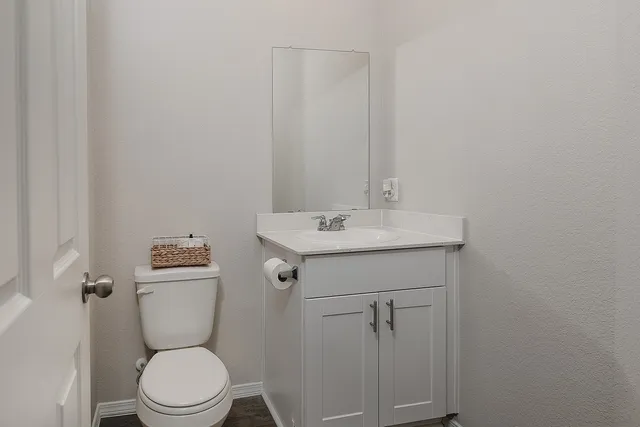 a bathroom with a sink a toilet and a mirror