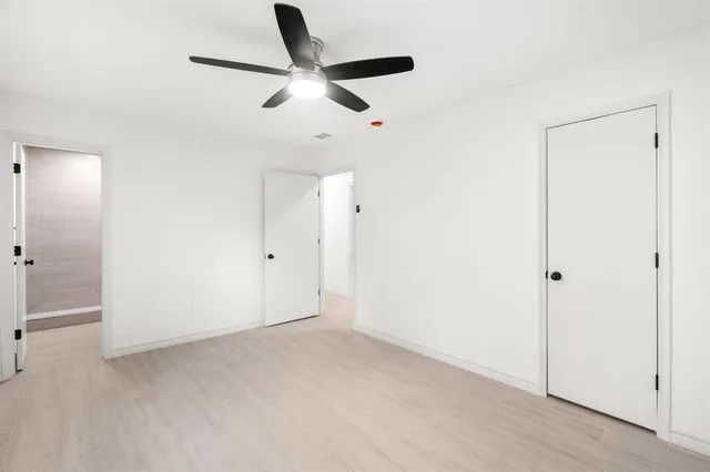 an empty room with a window and a fan