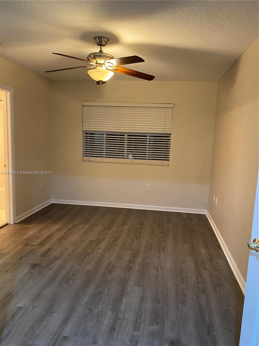 8395 Southwest 29th Street, Unit 102 Miramar, FL 33025 - Photo 2 of 20 a view of an empty room with wooden floor and a window