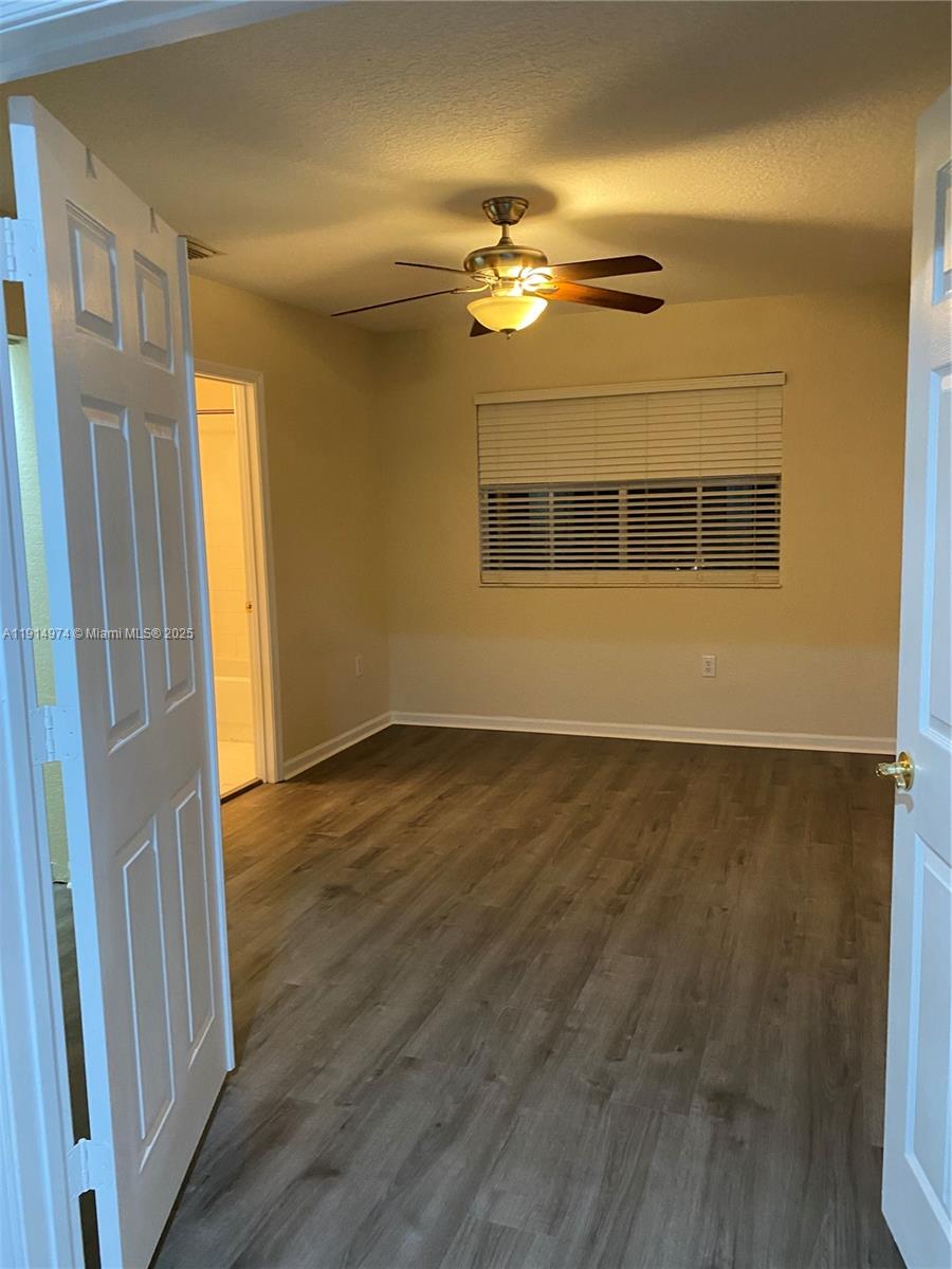 8395 Southwest 29th Street, Unit 102 Miramar, FL 33025 - Photo 3 of 20 a view of an empty room with wooden floor and a window