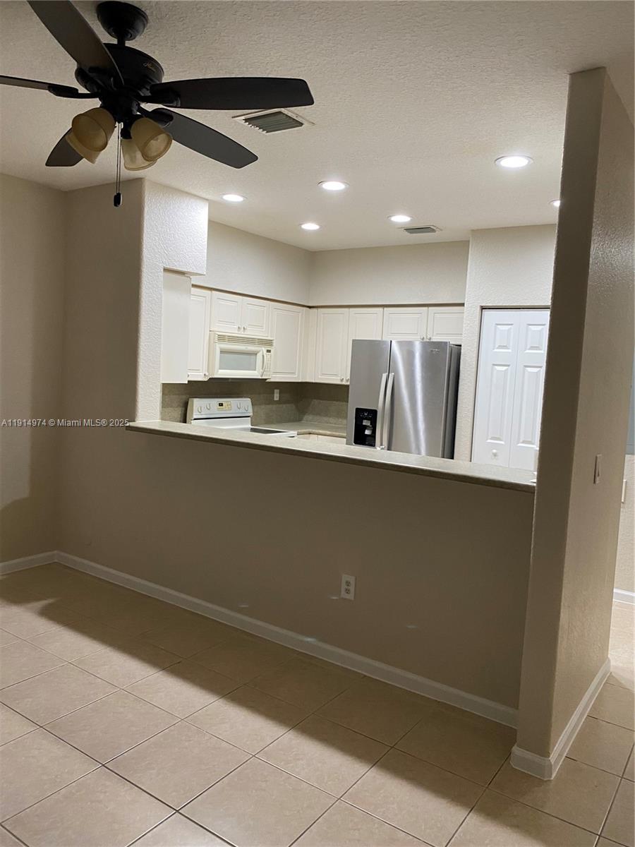 8395 Southwest 29th Street, Unit 102 Miramar, FL 33025 - Photo 6 of 20 a view of kitchen with stainless steel appliances granite countertop cabinets and a wooden floor