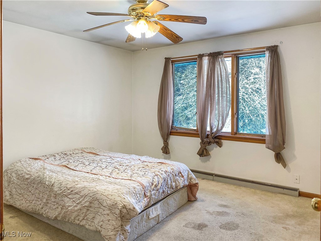 1034 Straub Road West Mansfield, OH 44904 - Photo 14 of 27 Bedroom featuring ceiling fan, a baseboard heating unit, and carpet floors