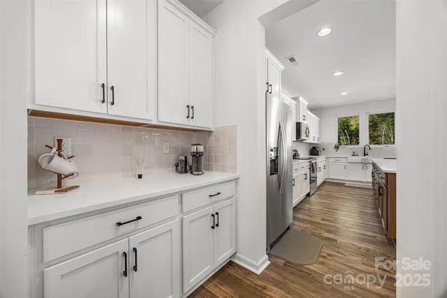a view of a kitchen with furniture and wooden floor