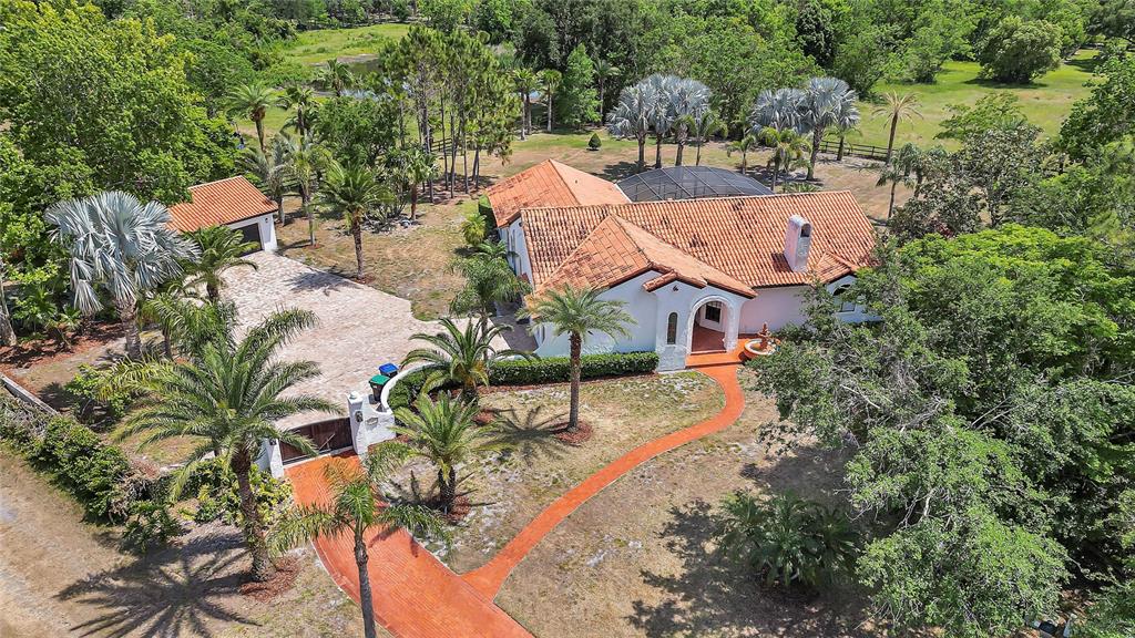an aerial view of residential houses with outdoor space and trees