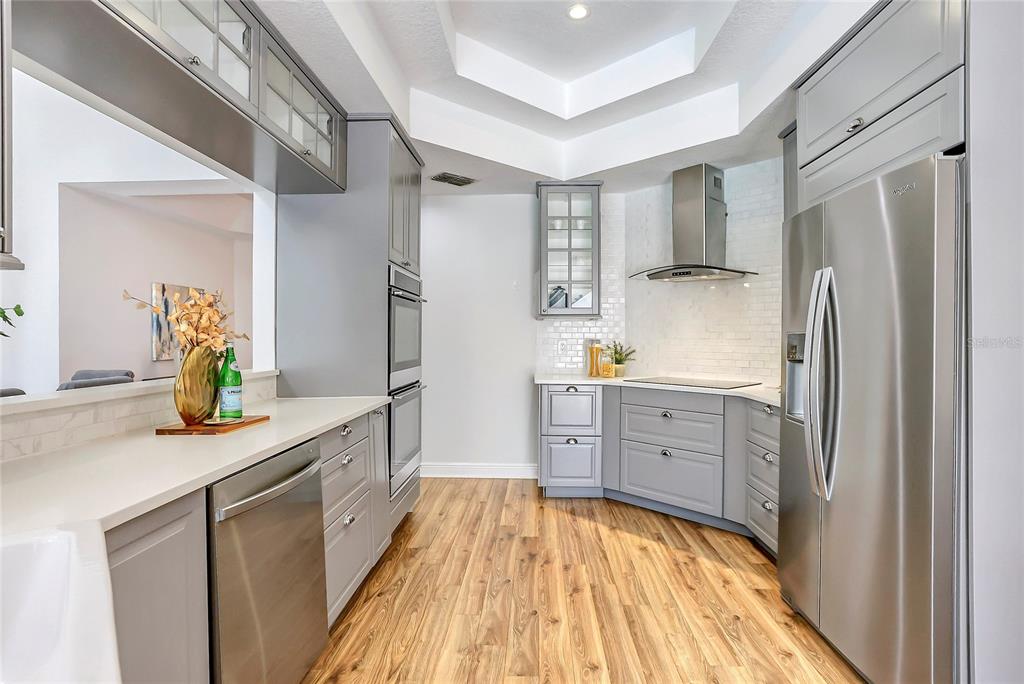 13124 Filly Court Windermere, FL 34786 - Photo 11 of 50 a kitchen with stainless steel appliances granite countertop a refrigerator a stove and white cabinets with wooden floor