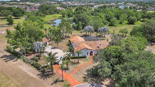 an aerial view of residential houses with outdoor space and trees