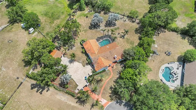 an aerial view of a house with a yard and trees