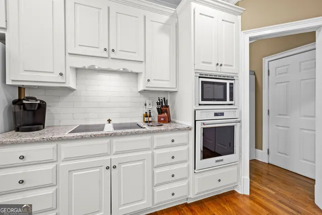 a living room with furniture a bookshelf and a window