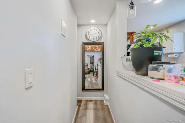 a hallway with painting on the wall and a potted plant