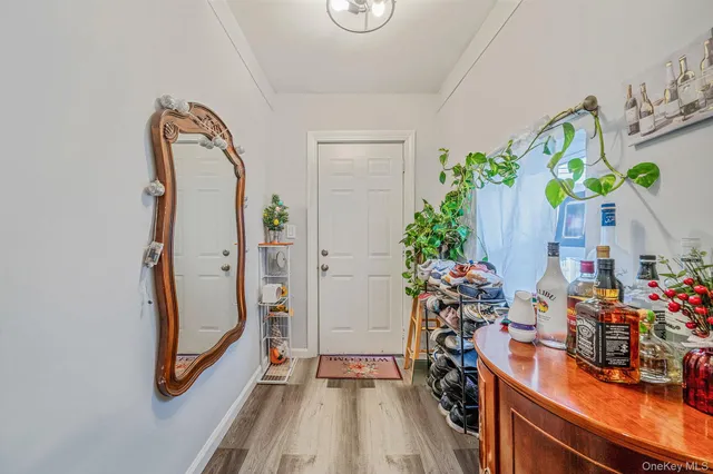a view of a hallway with wooden floor and a potted plant