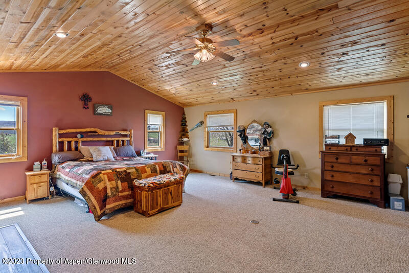 334 County Road 178 Craig, CO 81625 - Photo 14 of 19 a spacious bedroom with a bed and a chandelier