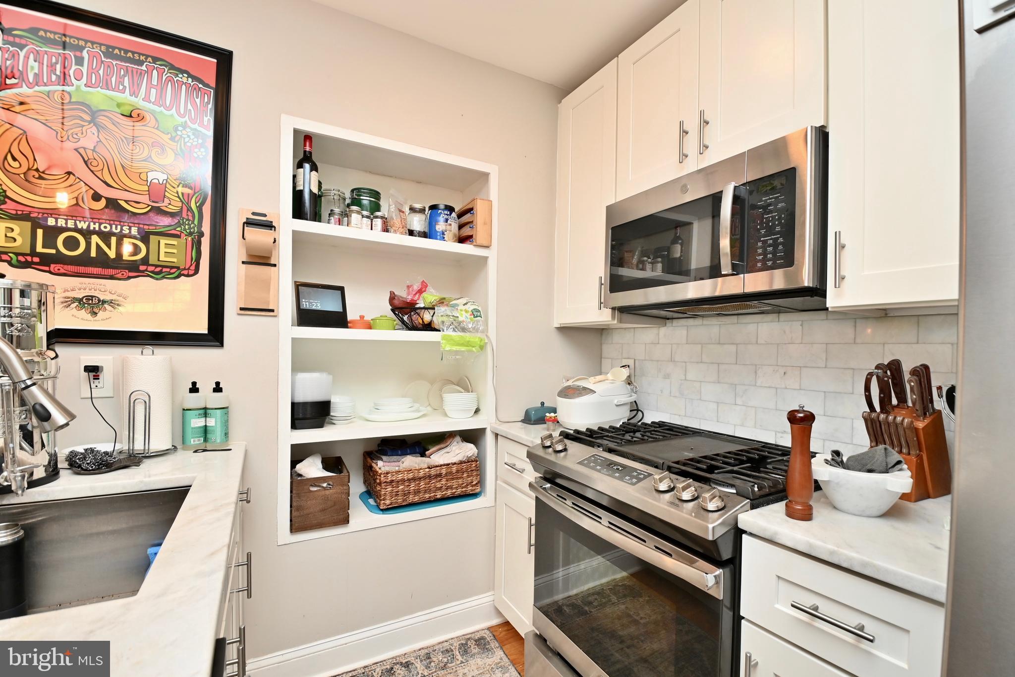 14 53rd Street Southeast Washington, DC 20019 - Photo 21 of 46 a kitchen with stainless steel appliances granite countertop white cabinets stove top oven and microwave