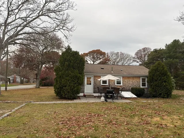 a front view of a house with a yard and trees