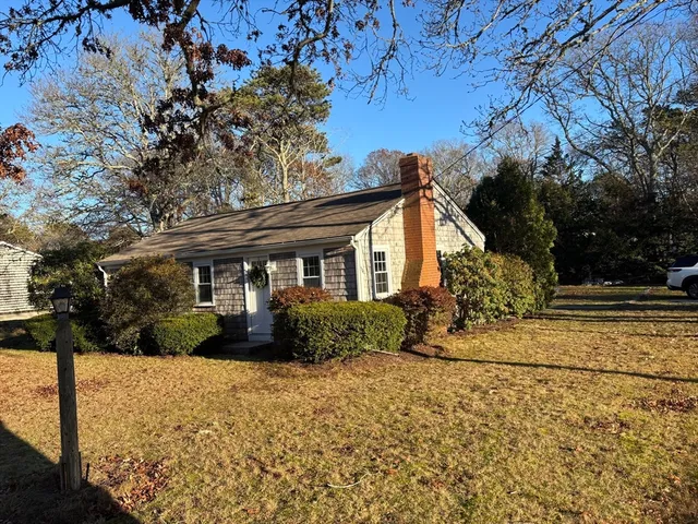 a front view of house with yard and trees around