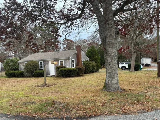 a front view of a house with a yard covered in snow