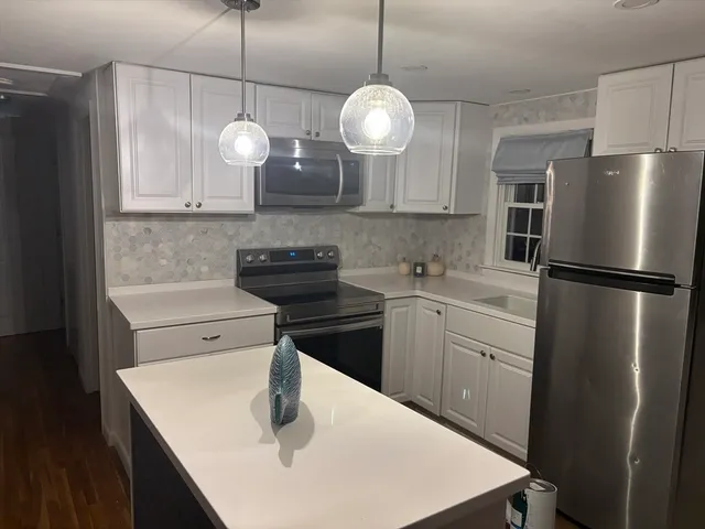 a kitchen with a sink a refrigerator and cabinets